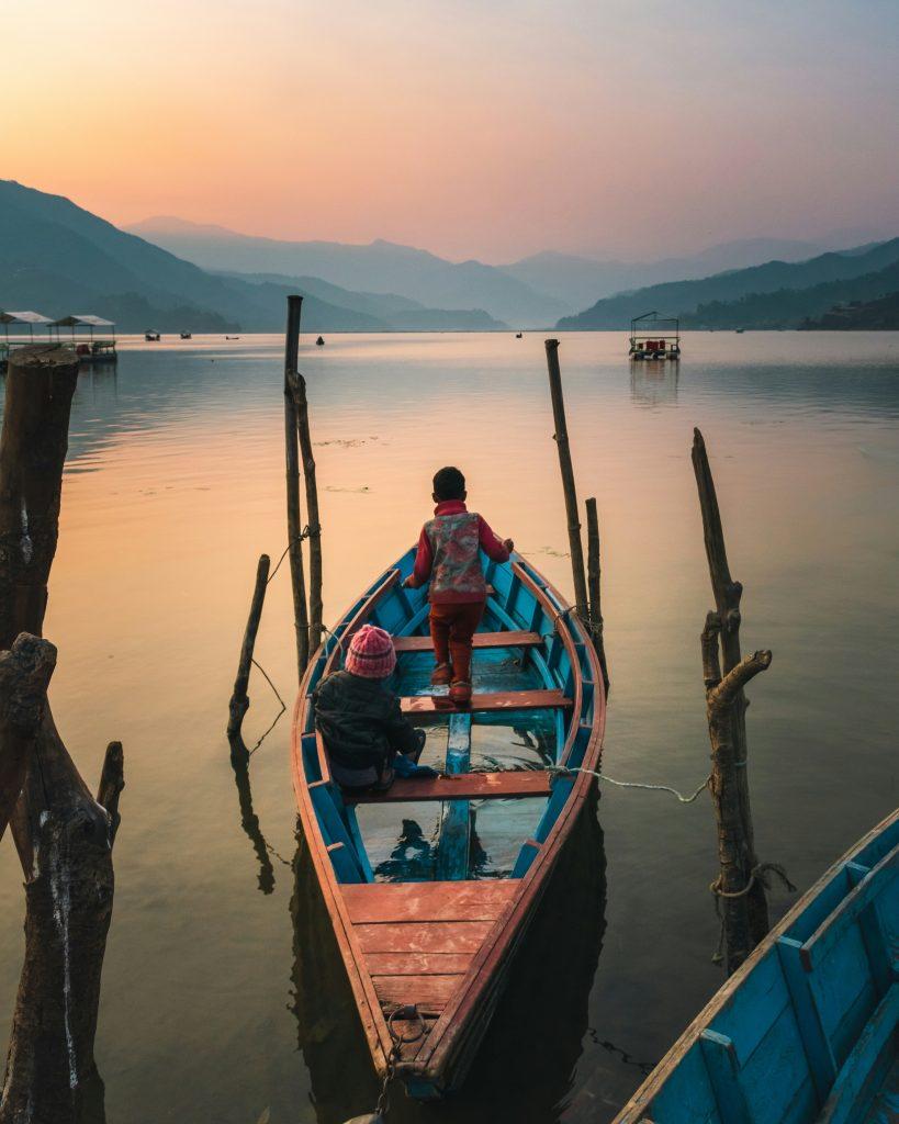  two small kids riding a boat in the phewa lake of pokhara 