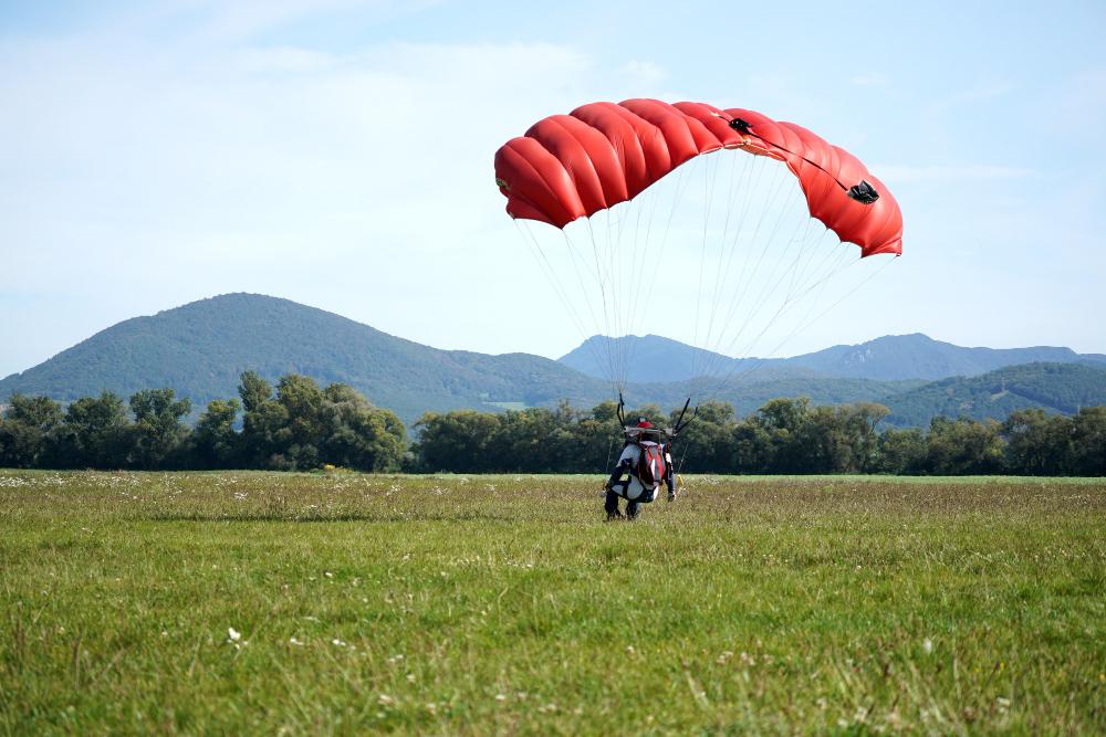 Paragliding activity in Pokhara with a pilot landing in an open field