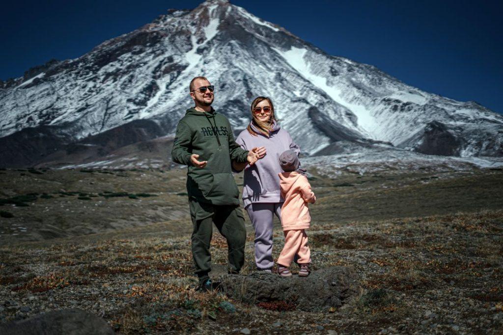A happy family relaxing and enjoying each other’s company near a mountain landscape, surrounded by nature and open scenery