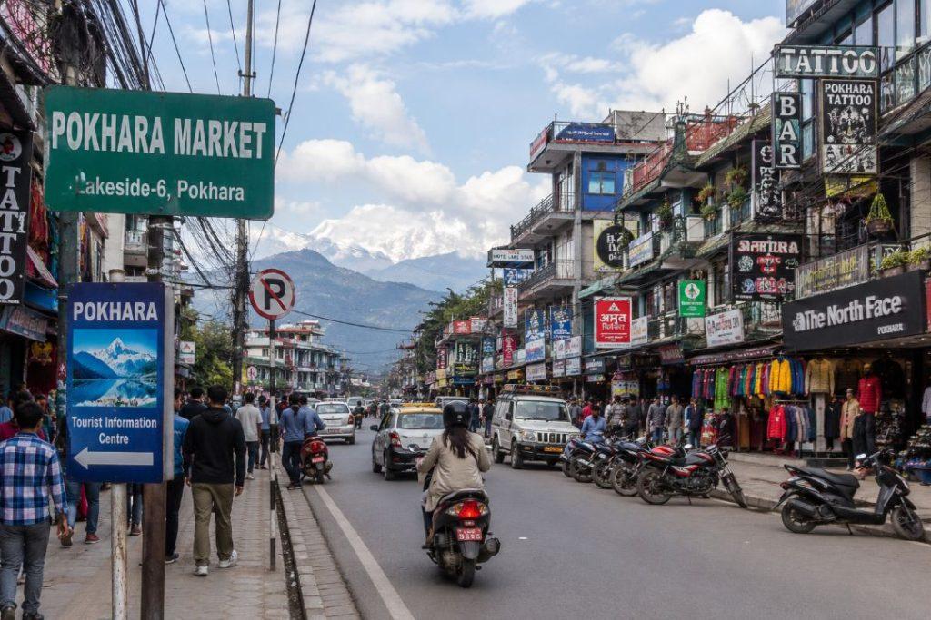 Busy Pokhara market street with local shops and visitors in Nepal.