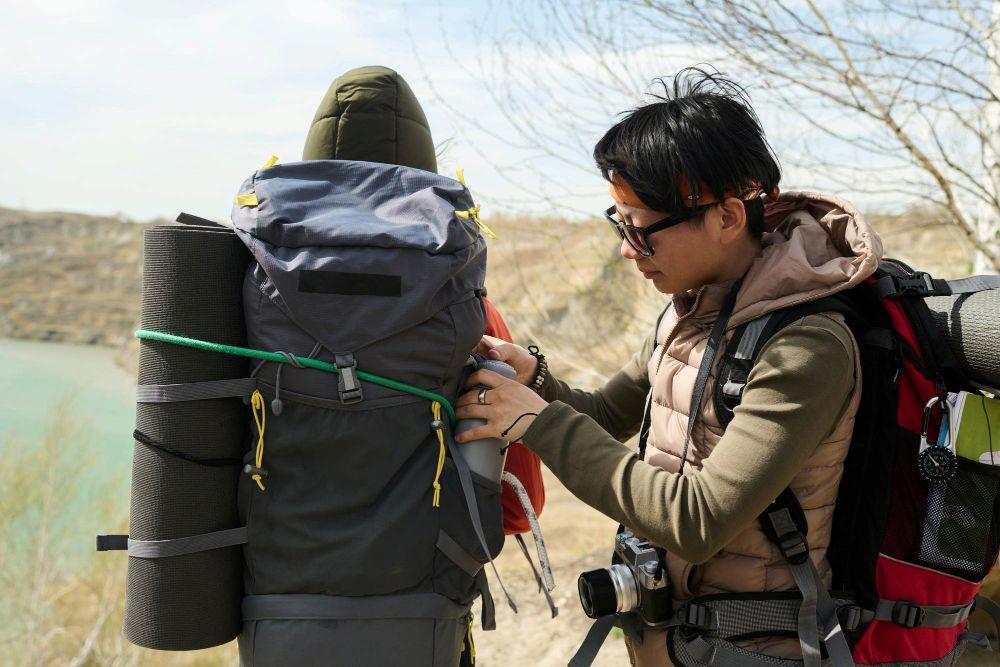 Trekker with backpack getting assistance or preparing for a hike in Nepal